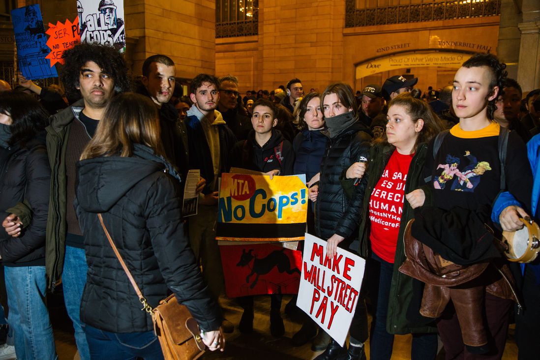 A group of protesters hold signs in Grand Central.